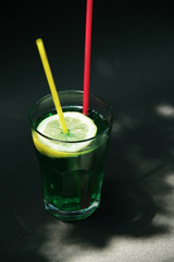 Green coctail on black background. Poison Ivy coctail. Summer drink. 