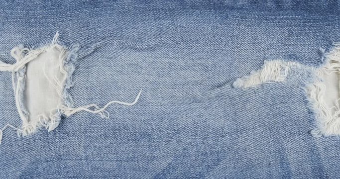 Rotation, blue torn jeans with holes. Jeans texture. Top view