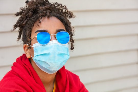 African American female young woman wearing sunglasses and face mask in COVID-19 pandemic