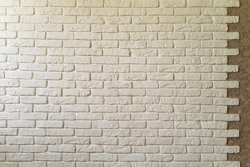 White brick wall in the interior. Textured background. White brick in the interior. White brick texture. Uneven designer brick edge
