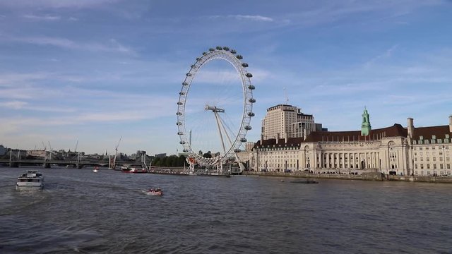 tourists enjoying boat trip along Themes river near Westminster, London (london eye in background)