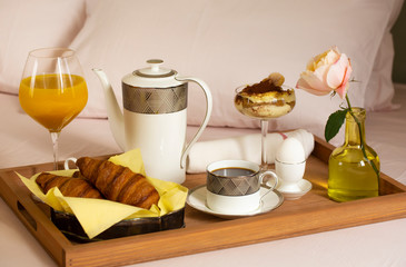 Tray with breakfast on a bed in a hotel room
