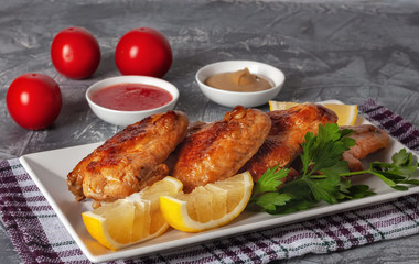 Grilled chicken wings with tomatoes, lemons and parsley