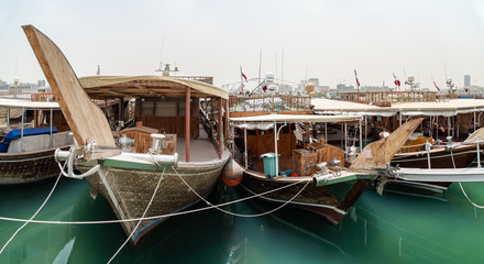 Fototapeta na wymiar Traditional wooden boats in the Corniche marina at Doha.