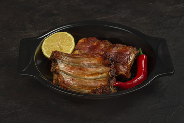 Baked pork ribs with lemon and hot pepper in a baking dish
