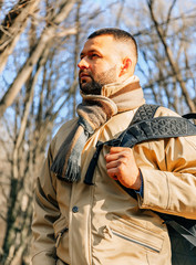 Obraz premium Beard man in the park. Young traveler in the forest. Lonely man with backpack and jacket. Adult serious man with black beard in the autumn park.