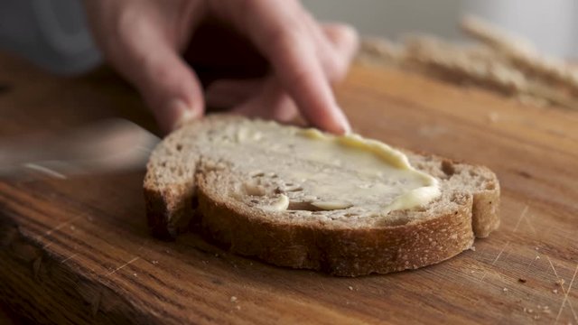 Spreading organic butter on bread. Bread and butter concept.