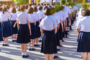 Asian hight school white uniform students stand in line to show respect for their national anthem and pray in the morning.