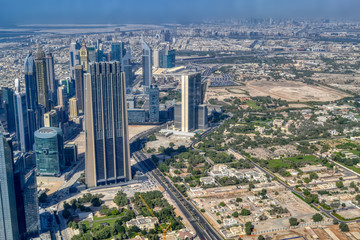 Dubai, United Arab Emirates - September 2, 2016. Urbanistic view of Dubai territories from the top of Burj Khalifa skyscraper, tall buildings on the sunny autumn day