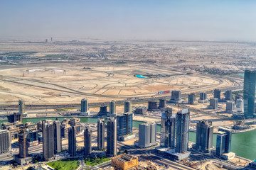 Dubai, United Arab Emirates - September 2, 2016. Urbanistic view of Dubai territories from the top of Burj Khalifa skyscraper, tall buildings on the sunny autumn day