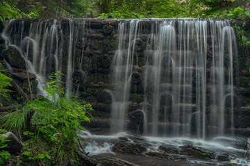 Fototapeta premium Waterfall on Divoky creek near Kouty nad Desnou village in summer day