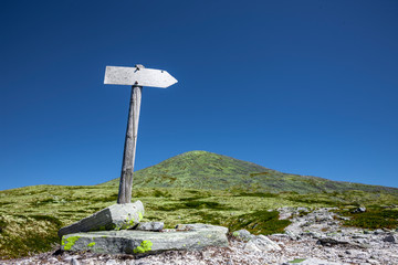 Wegweiser in Gebirgslandschaft