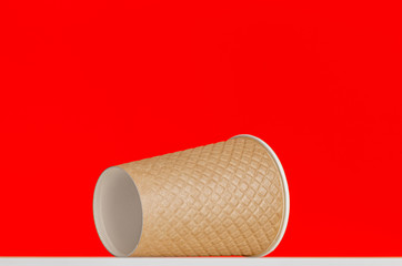 textured paper cup on red background 