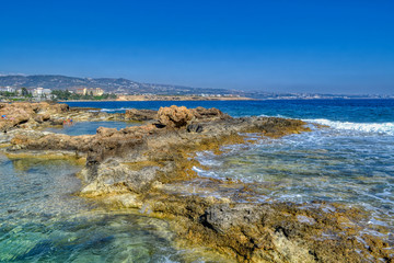 View of the rocky sea coast of the Mediterranean Sea in Paphos, Cyprus.  Coastal reefs and small puddles filled with sea water.