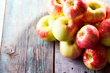 Composition of village red apples on a wooden table