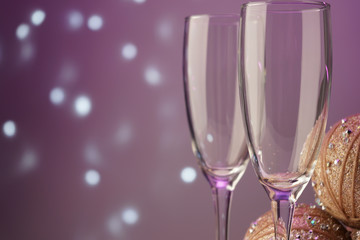glass glasses for sparkling champagne close-up on a lilac background with flickering lights in bokeh