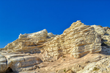 Rocks on the Mediterranean coast in Paphos, Cyprus.  Light clay mountains near the sea coastline.