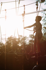 rope park. A boy passes an obstacle on tires in a rope Park.