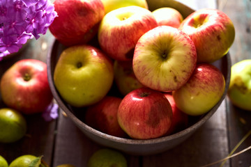 Composition of village red apples and small pears on a wooden table