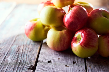 Composition of village red apples on a wooden table