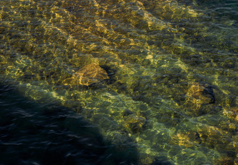 stones are visible through clear water