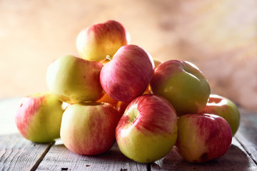 Composition of village red apples on a wooden table