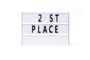 2 st place. Text on a vintage lightbox display placed on a white table on a light background. 