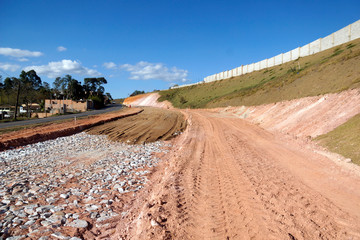 access road under construction, machines and vehicles do the heavy lifting