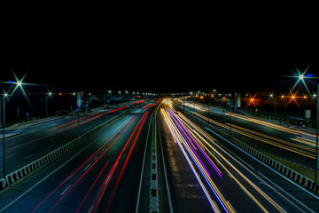 Fototapeta na wymiar night photograph of running cars on highway