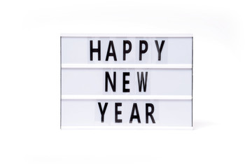 Happy new year. Text on a vintage lightbox display placed on a white table on a light background. 