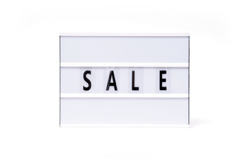 Sale. Text on a vintage lightbox display placed on a white table on a light background. 