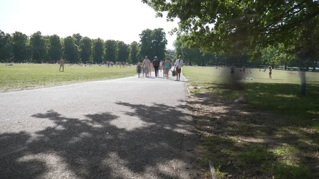 Time lapse. People walking on a sidewalk in a park.
