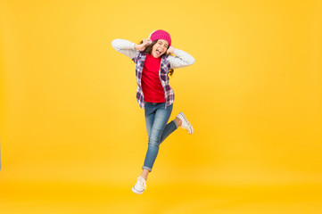 Fototapeta na wymiar Happiness is the secret to all beauty. Happy girl enjoy music yellow background. Energetic child jump of happiness. Happiness concept. There is power in positivity