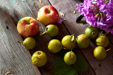 Composition of village red apples and small pears on a wooden table