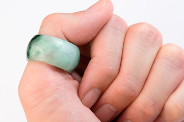 Green jade ring on thumb finger
