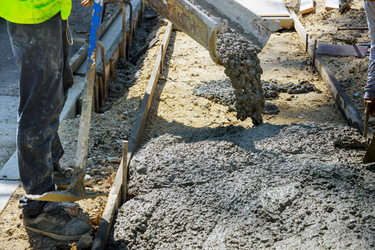 Construction worker pour cement for sidewalk in truck mixer pouring concrete cement for construction sidewalk