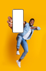 Excited african guy dancing with modern smartphone - obrazy, fototapety, plakaty