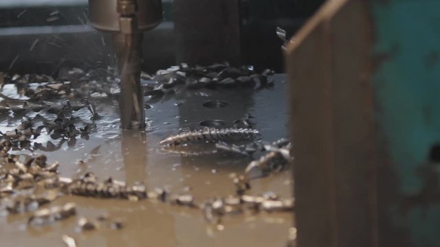 Industrial drill drilling an iron plate.