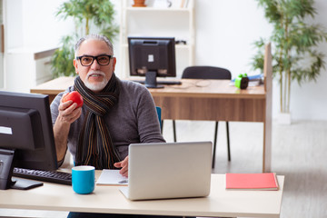 Old male employee working from house during pandemic