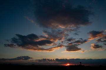 Black evening clouds at sunset. Clouds beat off red sunset light from the sun.