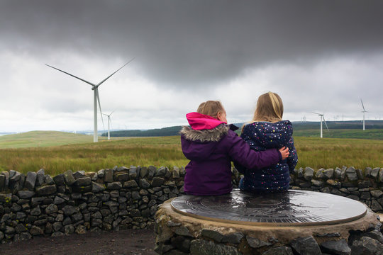 Two Little Childern Visiting A Wind Farm In Scotland On A Wet And Windy Summers Day