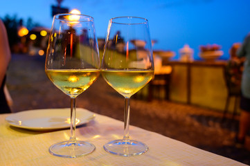 Two glasses of cold dry white wine served outdoor in cafe at night in Italy
