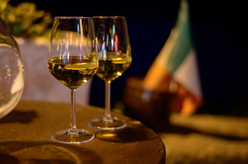 Two glasses of cold dry white wine served outdoor in cafe at night in Italy