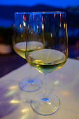 Two glasses of cold dry white wine served outdoor in cafe at night in Italy