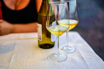 Two glasses of cold dry white wine served outdoor in cafe at night in Italy