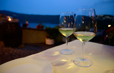 Two glasses of cold dry white wine served outdoor in cafe at night in Italy