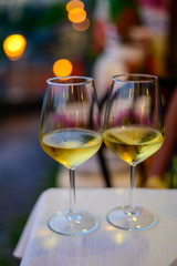 Two glasses of cold dry white wine served outdoor in cafe at night in Italy
