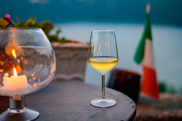 Glass of cold dry white wine served outdoor in cafe at night in Italy