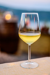 Glass of cold dry white wine served outdoor in cafe at night in Italy