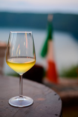 Glass of cold dry white wine served outdoor in cafe at night in Italy